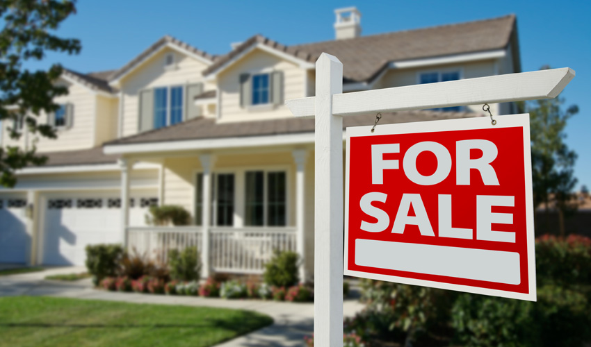 For Sale sign in front of a residential home